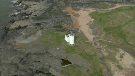 an aerial view of elie ness lighthouse and surrounding coastline on a misty day, fife, scotland