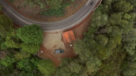 Absteigende-Luftaufnahme-über-Einem-Kleinen-Haus-Mit-Vorbeifahrendem-Fahrrad-Auf-Der-Straße