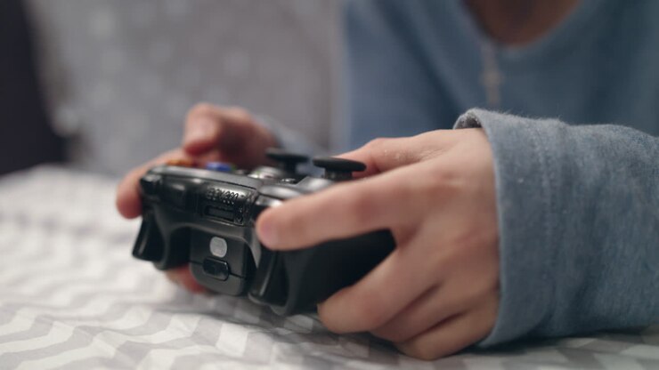 Mano di un bambino che gioca con il joystick. Primo piano della mano di un bambino che tiene in mano un joystick per videogiochi