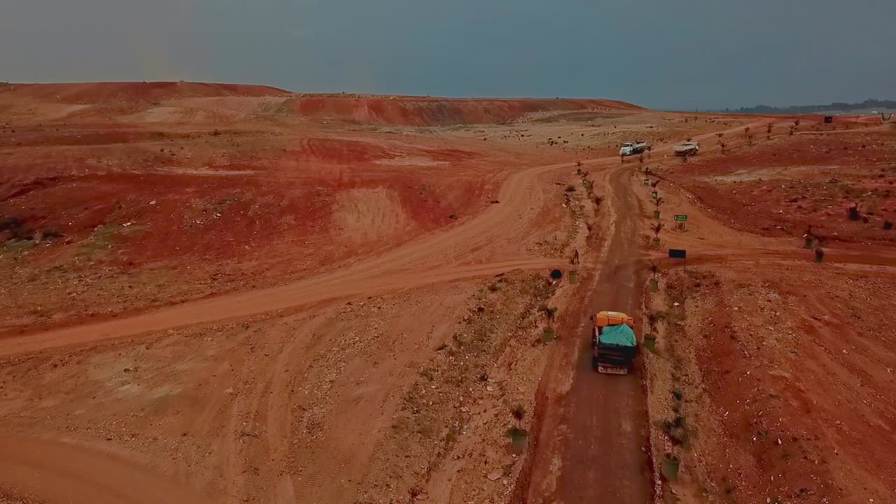 Aerial View of Mining Trucks on Red Dirt Road