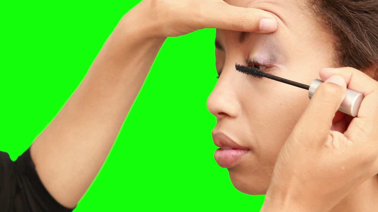 artista de maquillaje poniendo máscara en la cara de las modelos