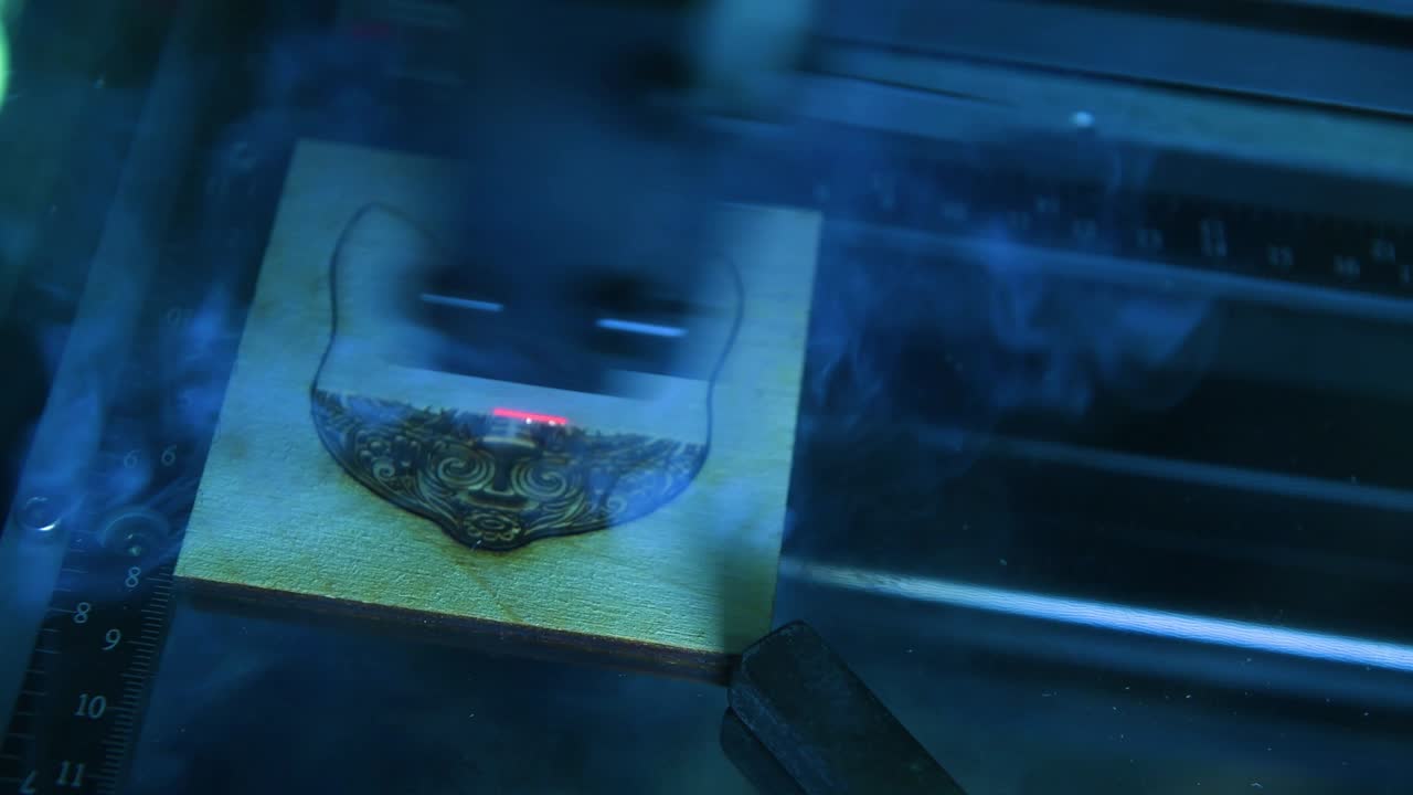 나무 패널에 작업하는 레이저 조각 기계, 그림을 그리는