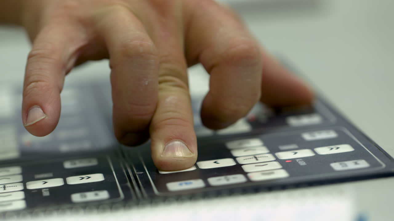 Closeup of caucasian man's hand operating a machine panel