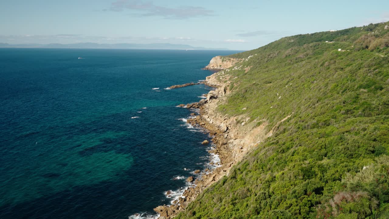 Le onde si infrangono lungo la costa rocciosa atlantica con acque turchesi a Tangeri, Marocco.