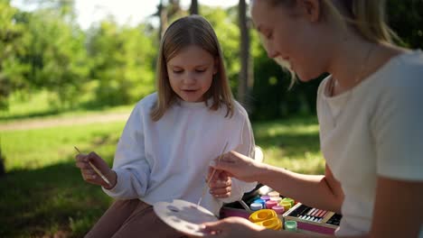 mother and daughter painting outdoors