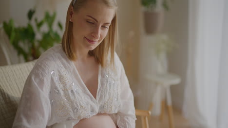 pregnant woman cradling newborn in cradle