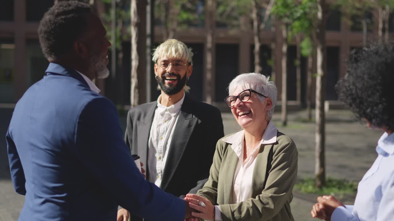 Business people shaking hands and kissing in an outdoor meeting point