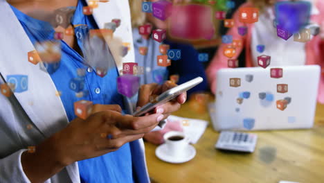 multiple digital icons floating against office colleagues using electronic devices