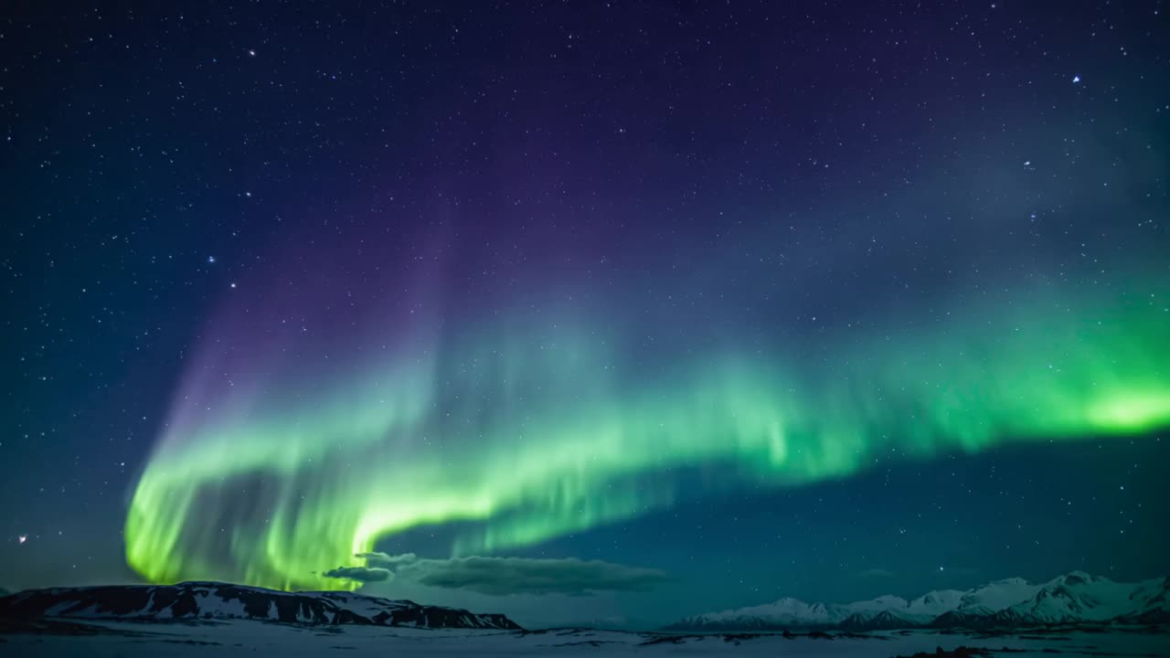 Vento solare che scatena l'aurora che passa da una banda a una colonna viola-verde per poi svanire su una cresta innevata