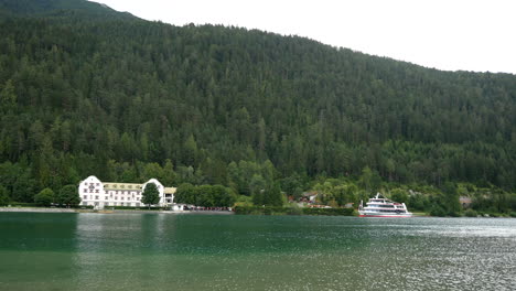 beautiful mountain landscape with forest ,hotel and parking tourist boat on achen lake,austria