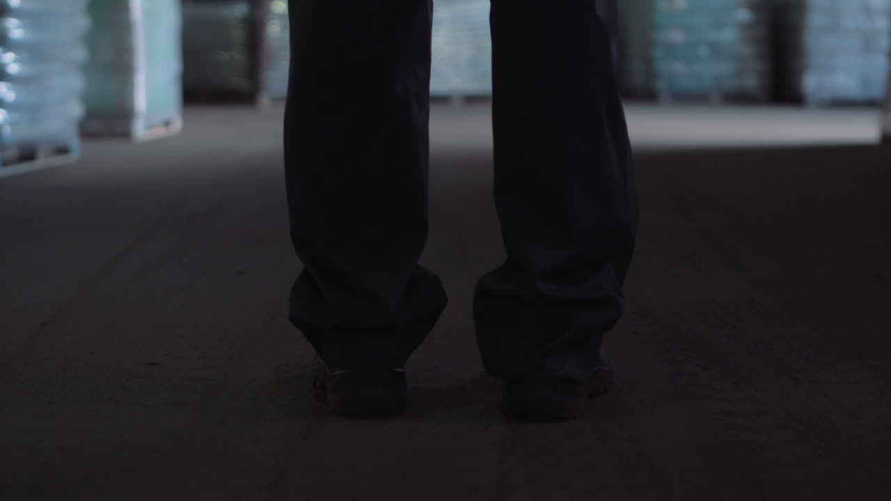 Person walking through a dark industrial warehouse