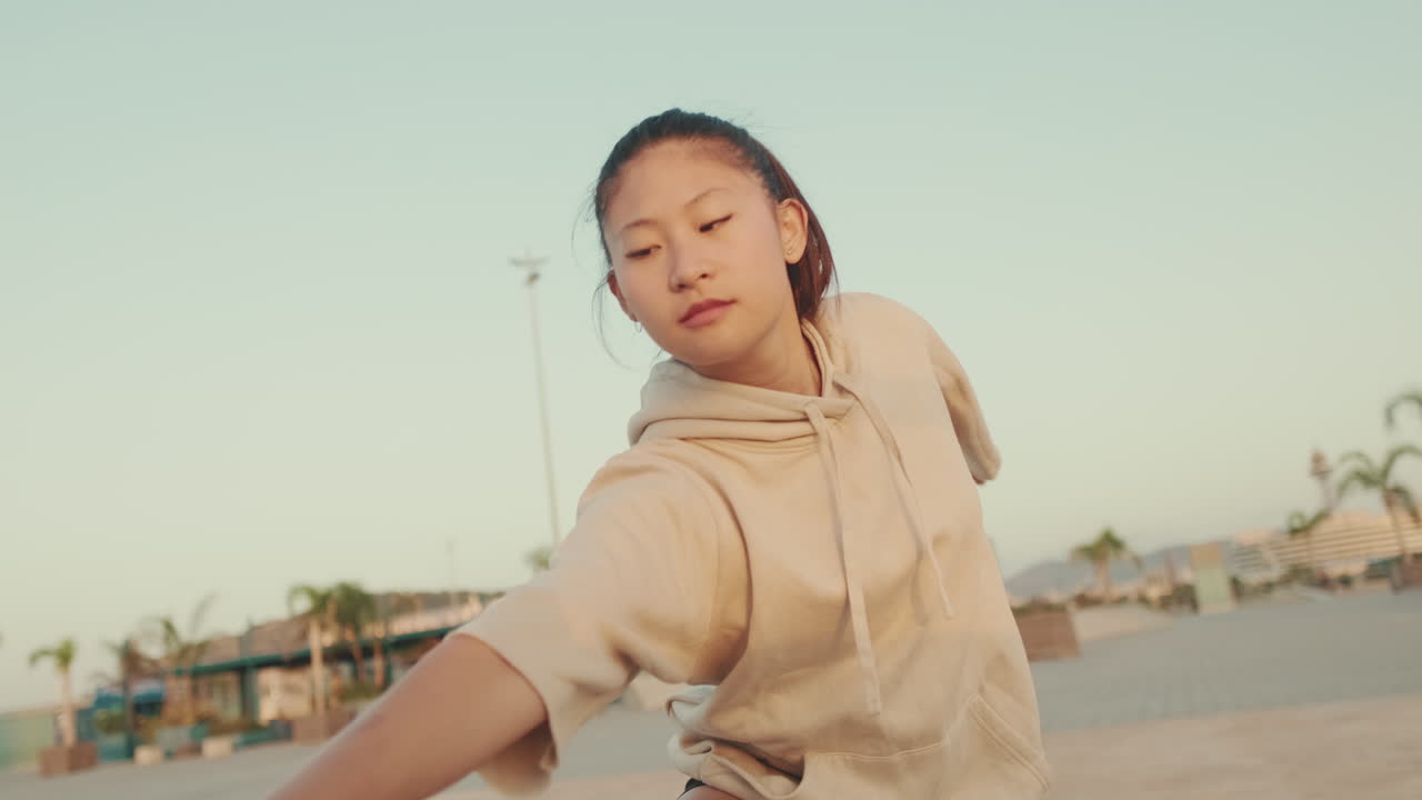 Young Asian woman in a hoodie on a beach