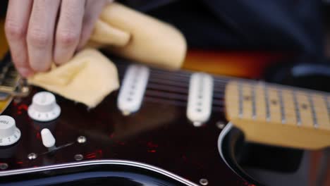 Man-gently-wiping-the-guitar-outdoor