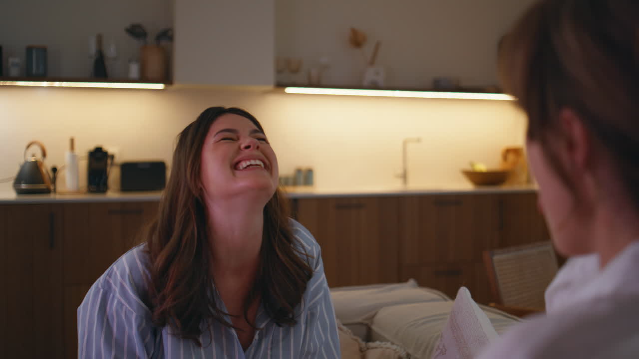 Smiling woman catching popcorn fooling with friend at evening home closeup