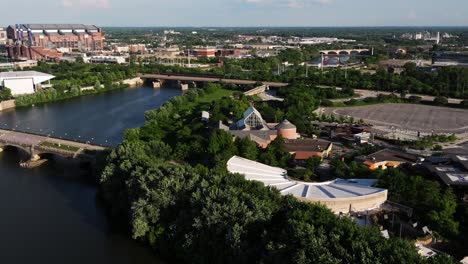drone orbits downtown indianapolis with views of white river, skyline, and surrounding architecture