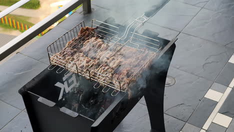 juicy steaks on a bbq outside on a balcony, food is about to be ready, grill is smoking, slow motion