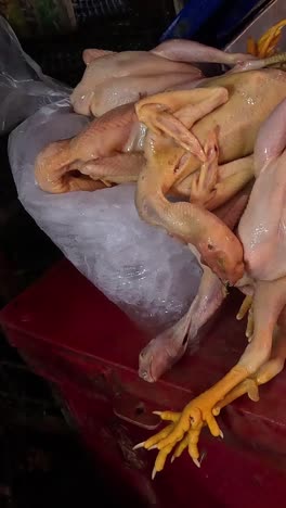 clientes recogiendo pollos en un mercado húmedo