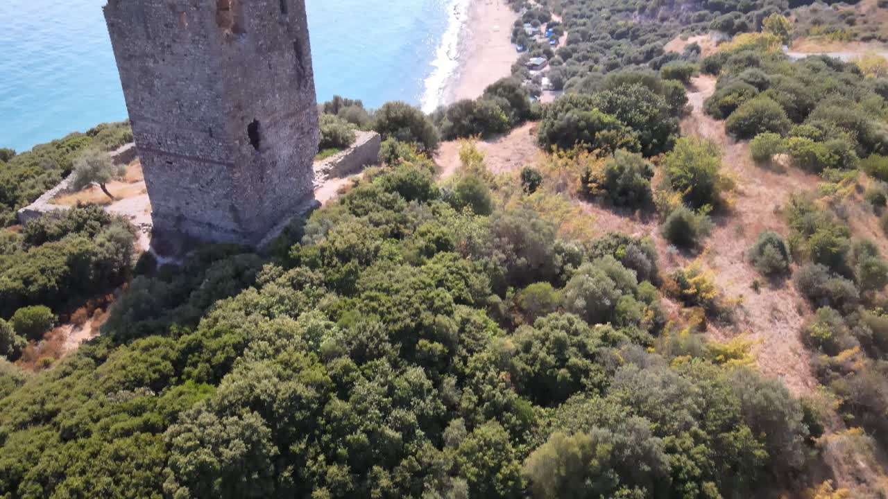 clip aéreo de drones sobre una antigua torre en ruinas y una playa en kavala, macedonia, grecia