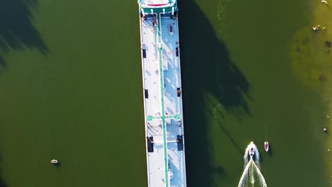 cargo ship in a canal with people on a beach