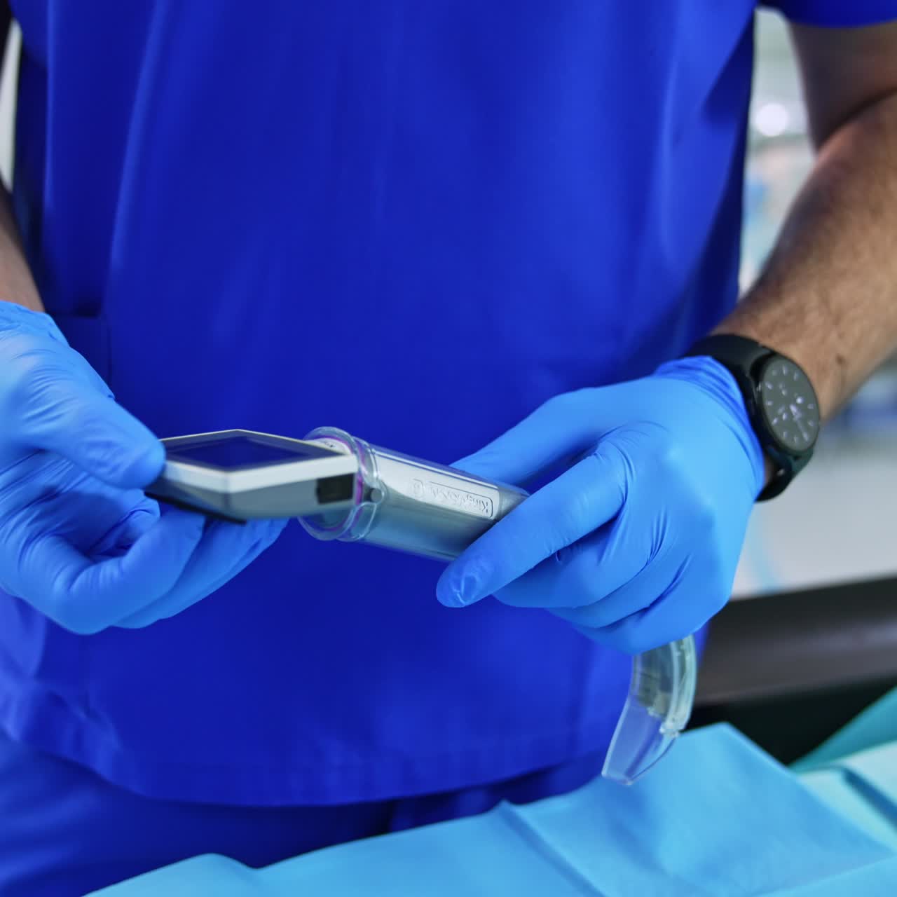 Uniformed medic in latex gloves holding video laryngoscope. Modern medical device for anesthesiologist's practice. Close up