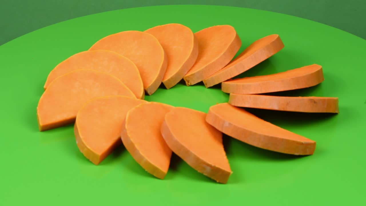 calabaza cortada en rodajas (cucurbita moschata, calabaza de nuez o grama de guitarra) aislada en verde. vista lateral. movimiento en bucle. rotación 360.