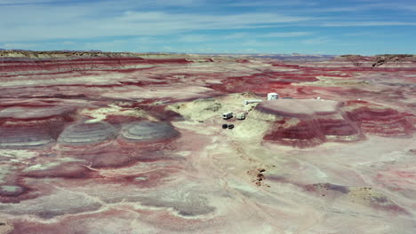 el dron lento asciende en la estación de investigación del desierto de marte en hanksville, utah durante el día con cielo azul y nubes blancas