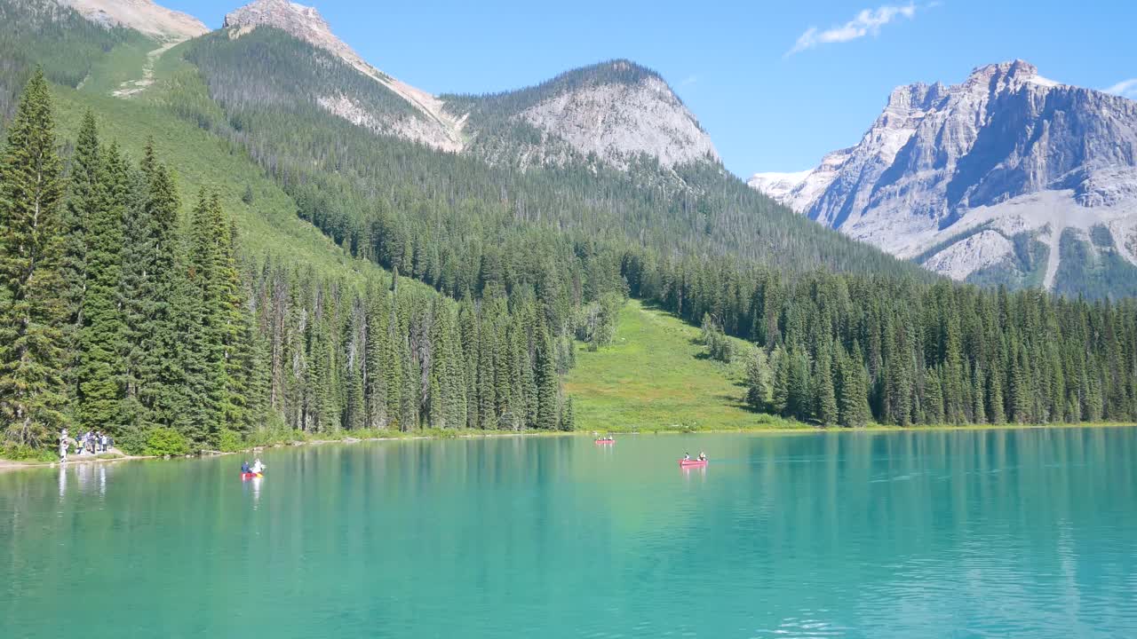 verano azul claro lago vista lago esmeralda con gente en canoa en el lago y hermosa cordillera con cielo azul claro en vacaciones de verano en el parque nacional yoho-banff, alberta, canadá