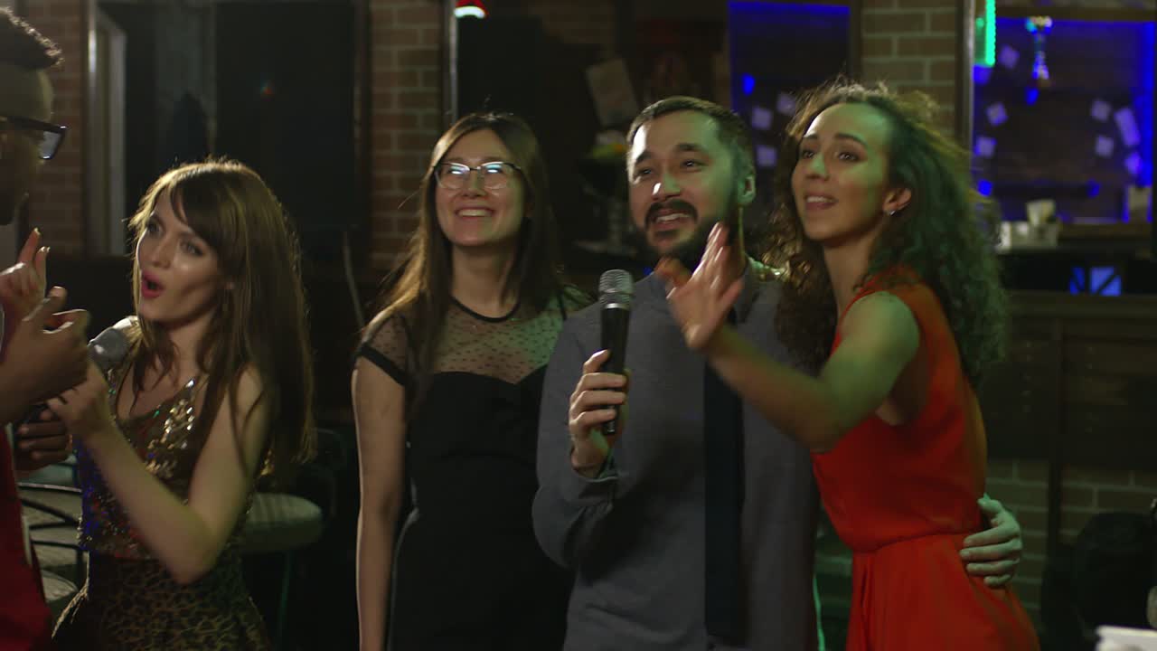 amigos divirtiéndose en el bar de karaoke