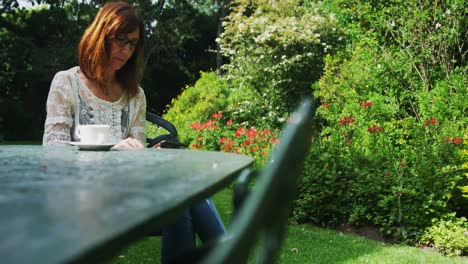 mujer madura leyendo un libro en el jardín 4k