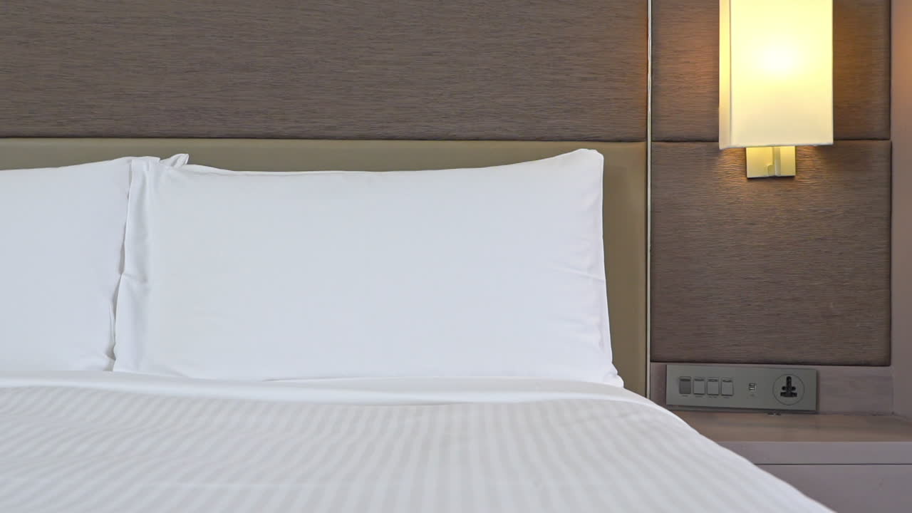 pan a través de los pies de la cama a través de las almohadas apoyadas