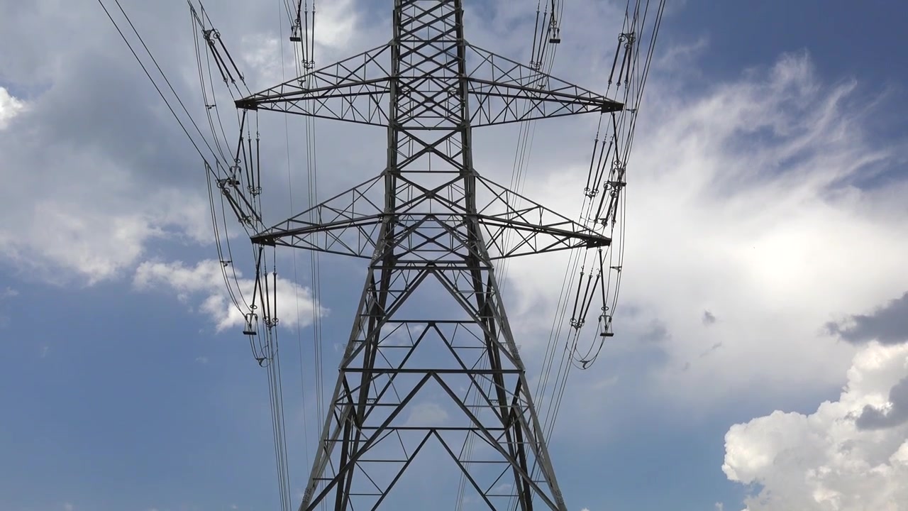 Large Metal Electricity Transmission Tower Against Blue Sky