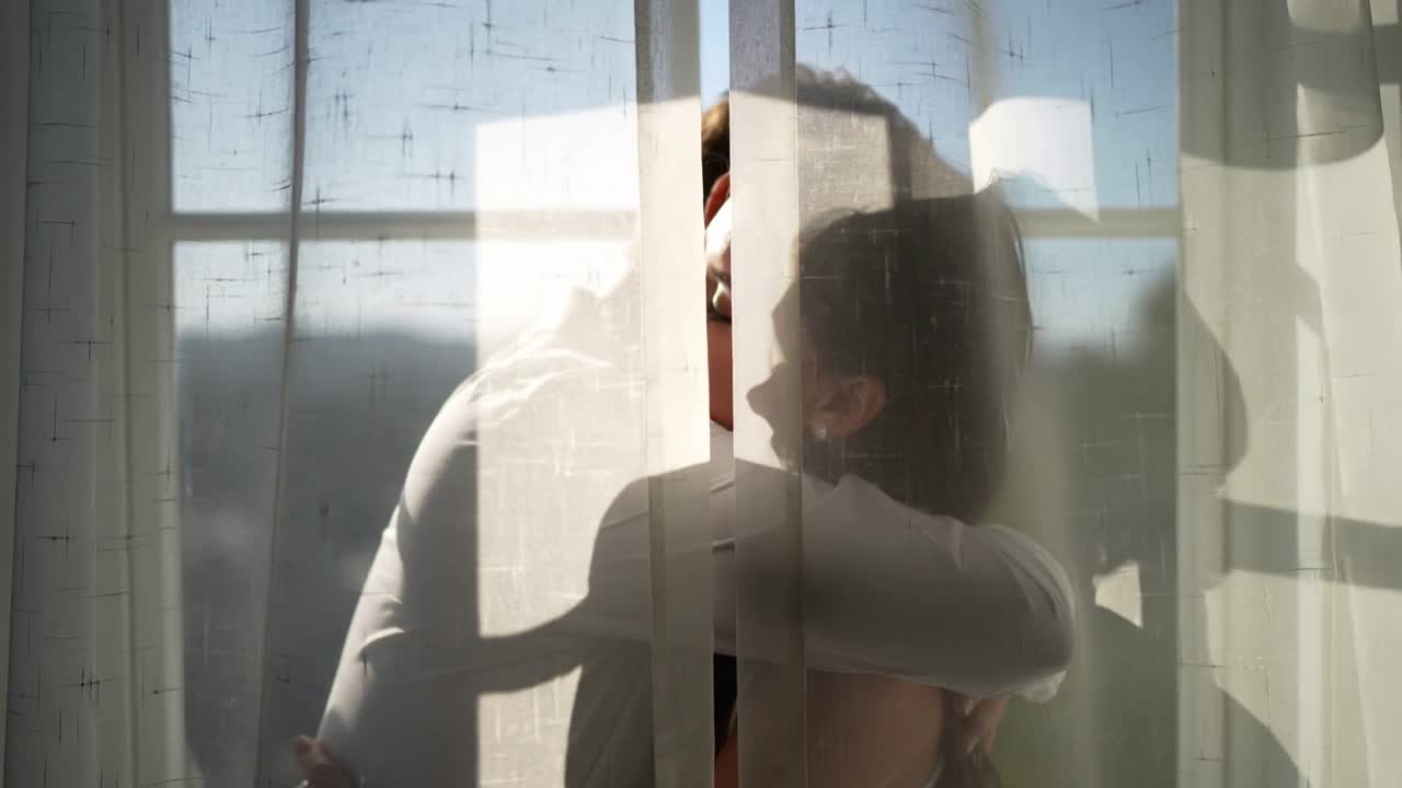 Starting hug couple holding resting head seeking comfort by sheer-curtain window in light-dark tops