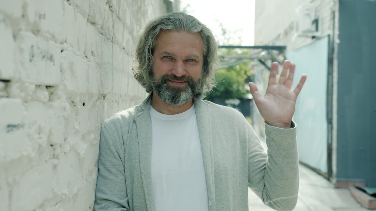 Friendly older man waving hello