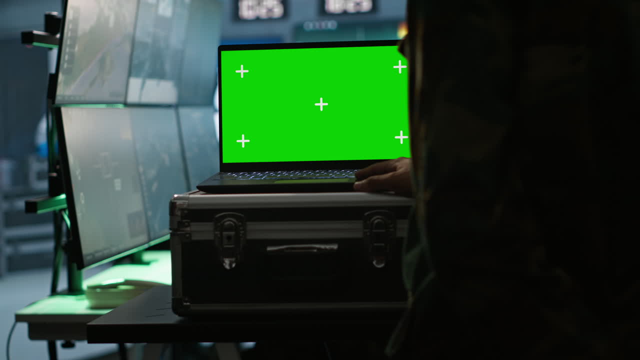 Army specialist operating surveillance tech with chroma key laptop