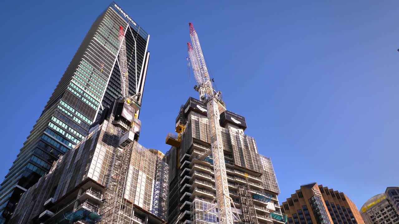 Modern Skyscrapers and a Building Under Construction Against a Blue Sky