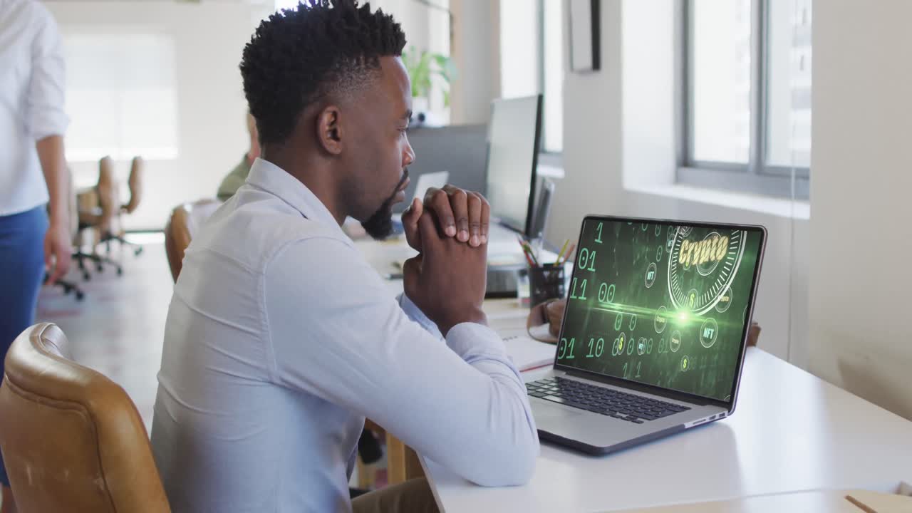 Video of african american man working on laptop with crypto money on screen