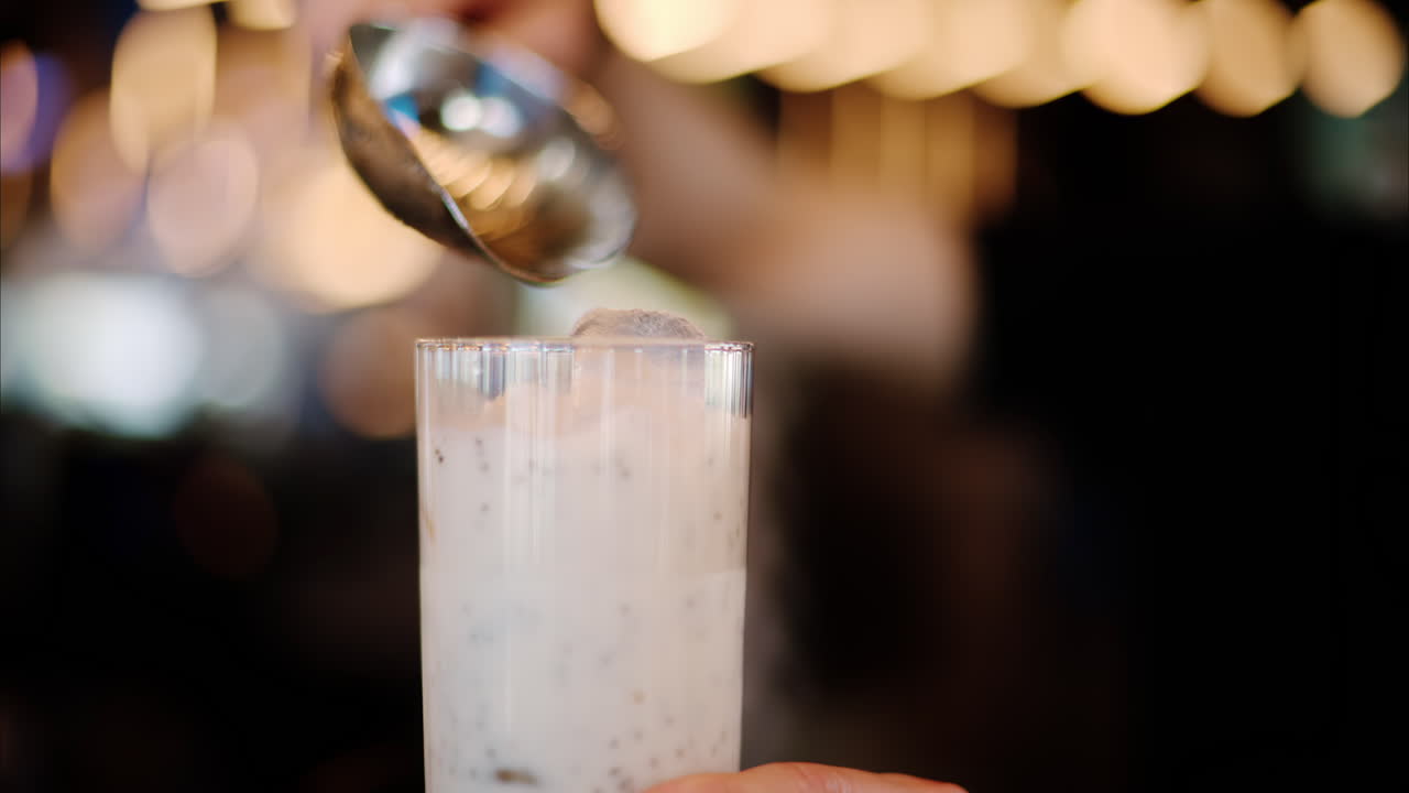 Man pouring ice in a strawberry drink