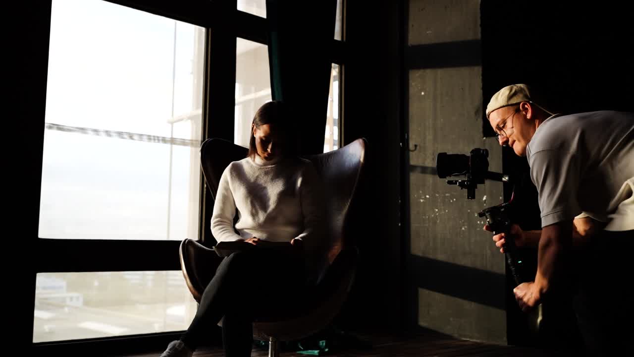 실내 자연 조명 스튜디오, 비디오 촬영자 영화 모델 가죽 달 의자에 앉아