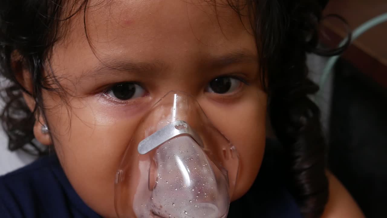 niña indonesia está siendo nebulizada para curar su tracto respiratorio