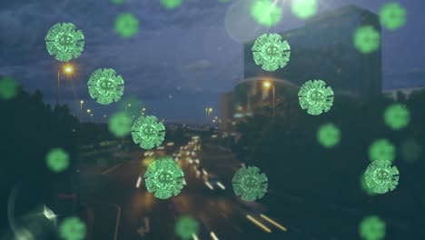 Multiple-green-covid-19-cells-against-aerial-view-of-night-city-traffic