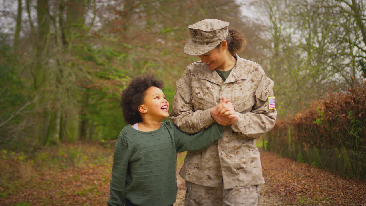 American Female Soldier Returning Home On Leave To Family Walking With Daughter Holding Hands