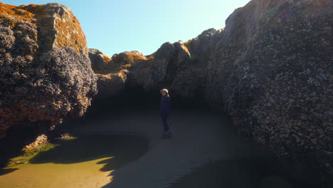 woman inside a cavern on the side of the beach