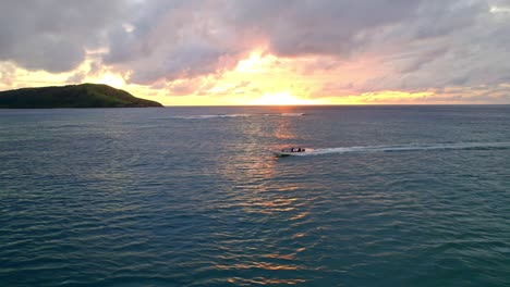 people cruising on tender boat during a vibrant golden sunset, yasawa, fiji