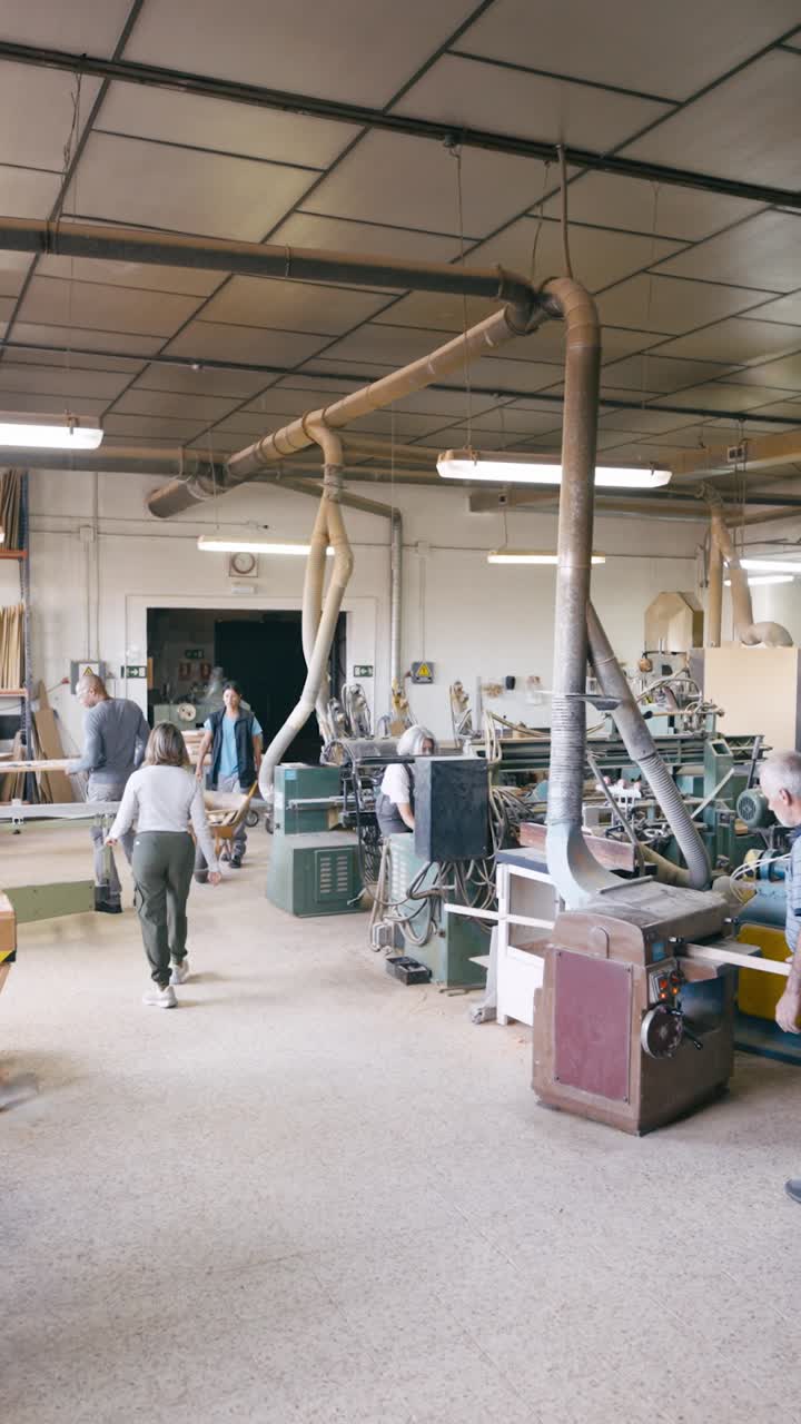 People Working and Moving in a Woodworking Workshop