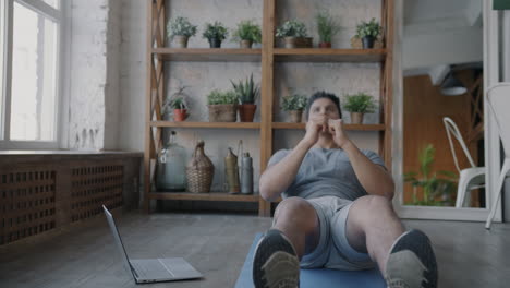 man doing online workout routine at home