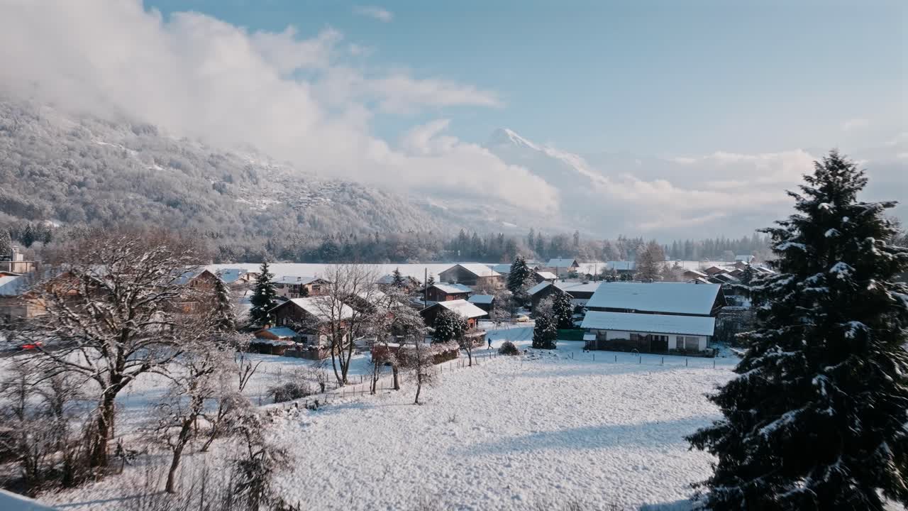 Snow-covered rooftops in Giffre Valley with mountain backdrop and winter light
