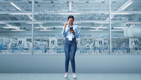 woman celebrating success in a modern factory