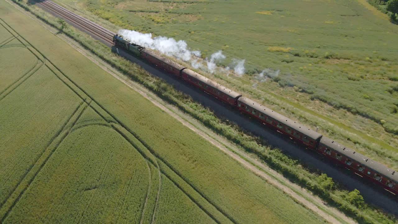 영국 시골의 철로를 통과하는 증기기관 기관차 열차의 조감도