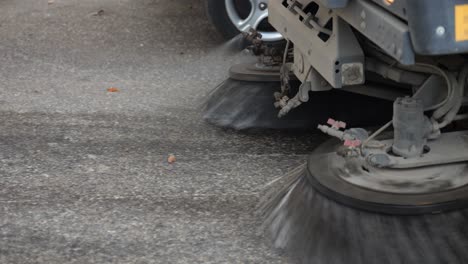 Vehicle-road-sweeper-brushes-operating-on-street