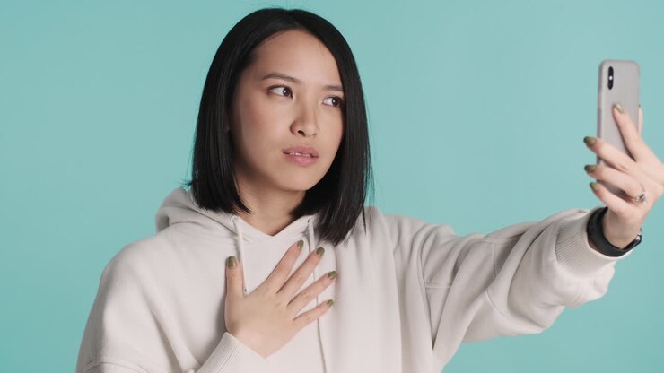 Asian woman having video call on smartphone.